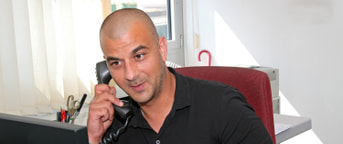 Migrol Mitarbeiter mit schwarzem Shirt am Telefon Migrol Mitarbeiter mit schwarzem Shirt am Telefon